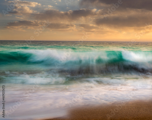 long exposure shot from the waves in the beach of Chabahar at sunset located in baluchistan, iran. waves hitting the rocks over oman sea. beach with cliff and rocks.