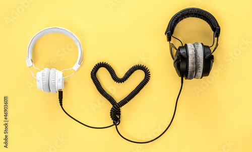 Flat lay musical background with black and white headphones.