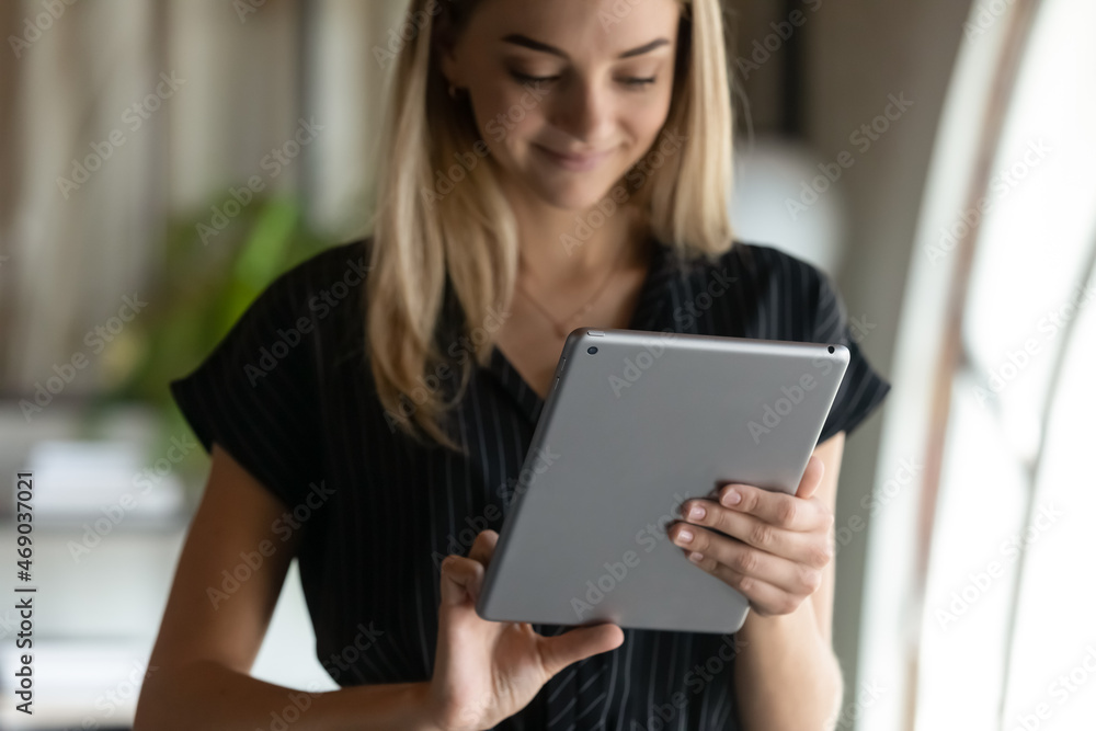 Smiling attractive young businesswoman manager employee holding digital computer touchpad tablet, web surfing useful information online, using software corporate applications, playing internet games. Smiling attractive young businesswoman manager employee holding digital computer touchpad tablet, web surfing useful information online, using software corporate applications, playing internet games.