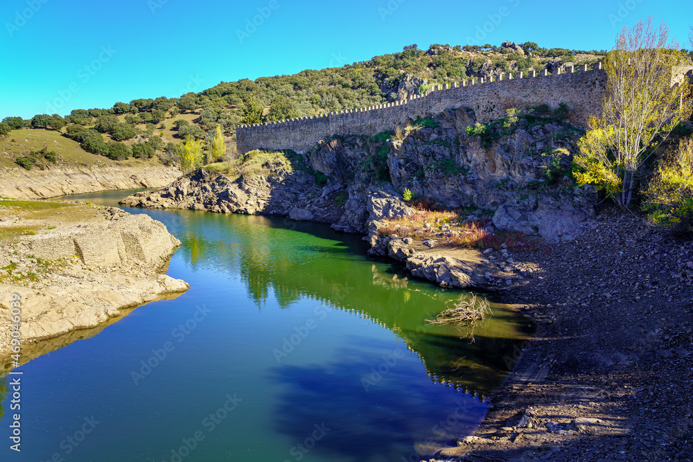 Rio Lozoya next to the old stone wall of the city of Buitrago Madrid.