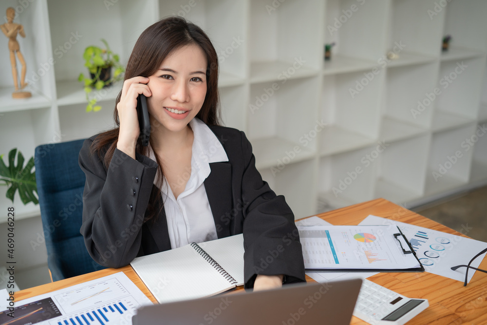 Women using laptops and smart phone in the office. Beautiful girl at the desk looking at the camera. Women using laptops and smart phone in the office. Beautiful girl at the desk looking at the camera.