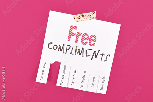 Tear off note with motivational free compliments on pink background photo