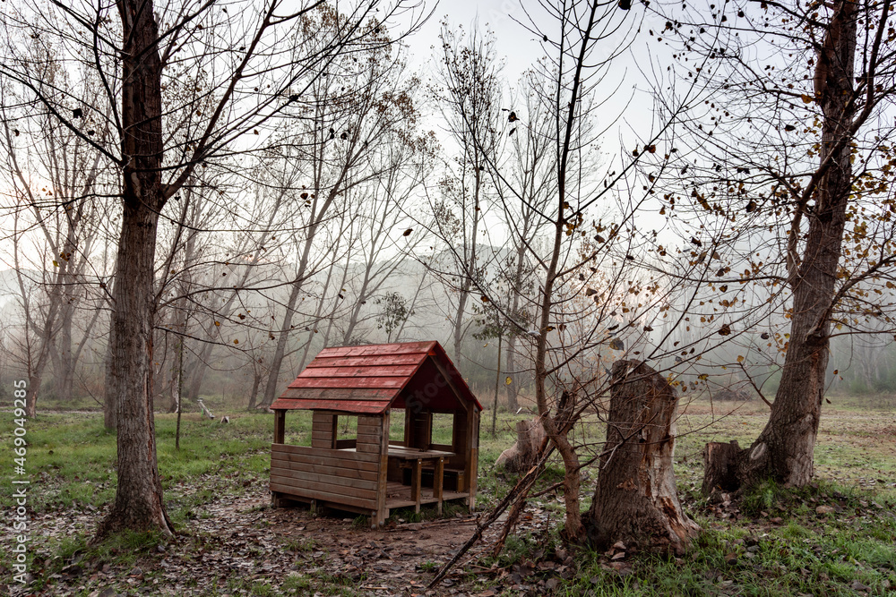 Wooden hut for children's games, abandoned in an autumnal park. Dystopian concept Wooden hut for children's games, abandoned in an autumnal park. Dystopian concept