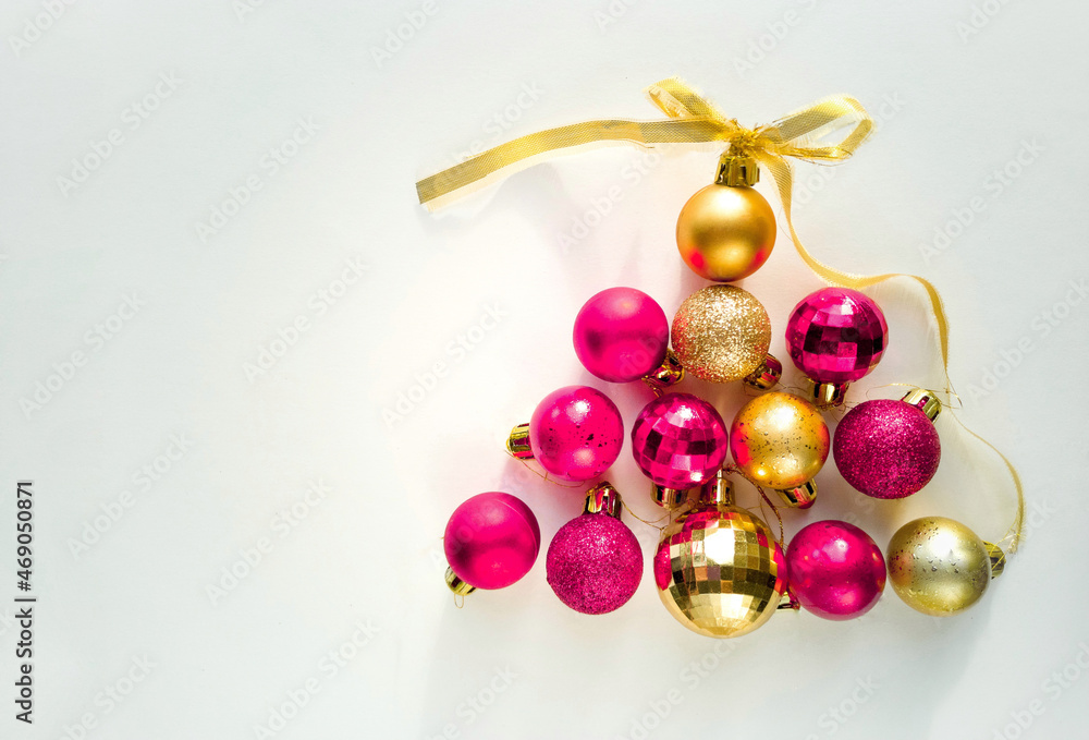 Christmas balls in the shape of a pyramid. New Year background. Pink and gold Christmas balls on a white background with a place for text. Christmas balls in the shape of a pyramid. New Year background. Pink and gold Christmas balls on a white background with a place for text.