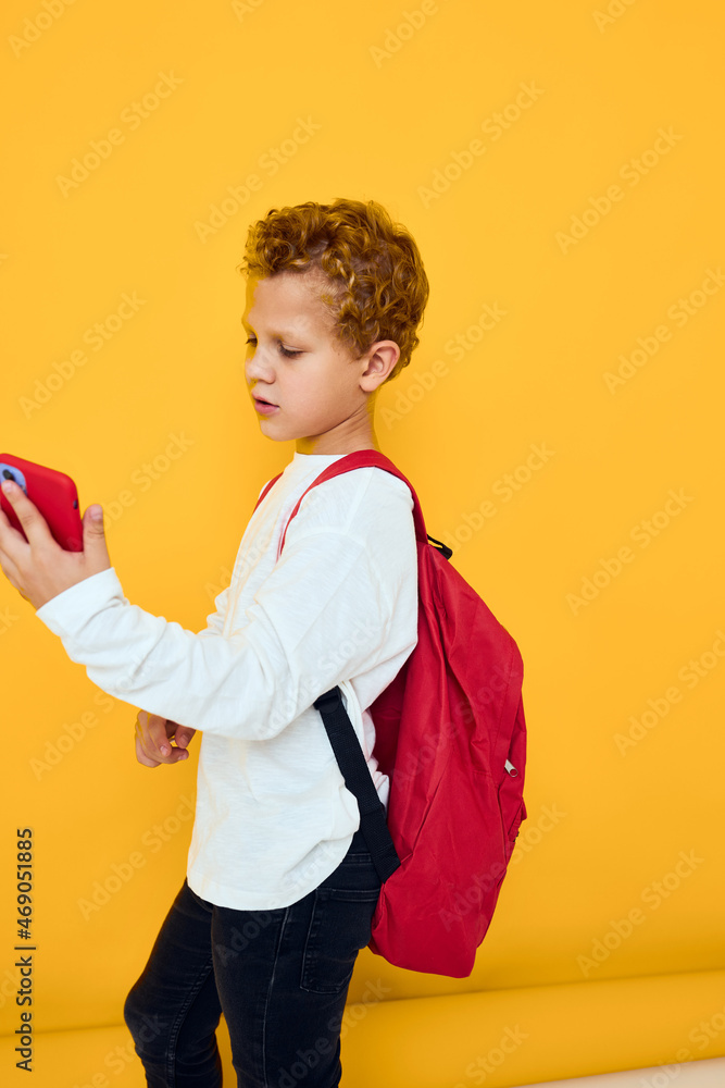 teenager boy in white sweatshirt mobile cell phone red backpack yellow background teenager boy in white sweatshirt mobile cell phone red backpack yellow background