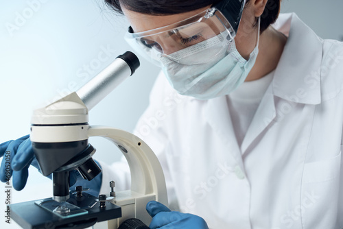 laboratory assistant sitting at the table microscope research biotechnology close-up