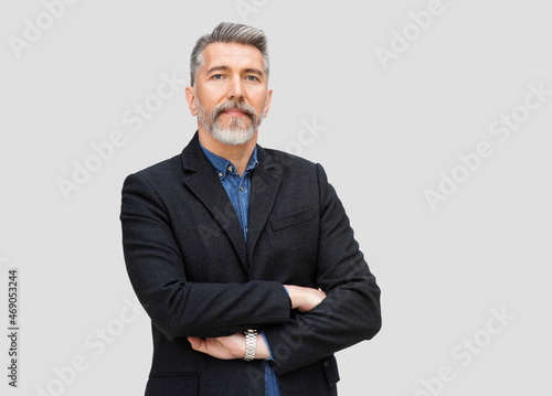 Portrait of serious mature man with folded arms. Confident middle age men with crossed hands isolated studio shot