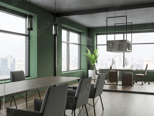 Corner of green office area with meeting table and workstation on background © ImageFlow