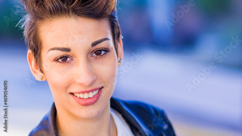 headshot froma a yooung hispanic female. Beautiful woman with an ambiguous hairsyling