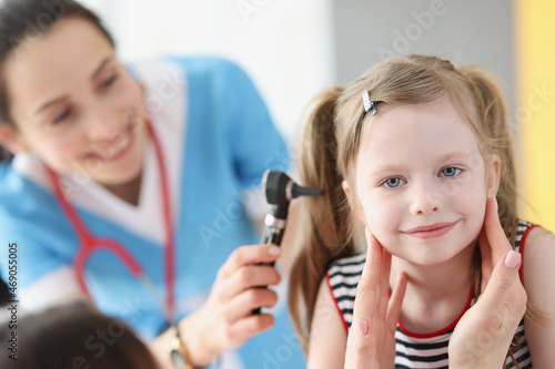 Woman doctor check the health of a girl s ears  close-up