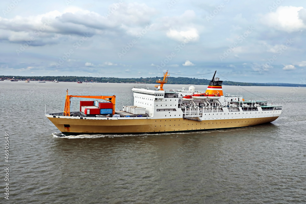 Fototapeta premium Vessels, passenger ships and tugboats in port under cargo operations and underway. Port of Surabaya, Indonesia, January,2021