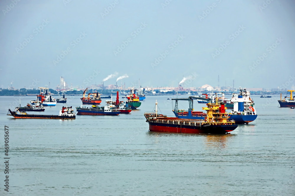 Vessels, passenger ships and tugboats in port under cargo operations and underway. Port of Surabaya, Indonesia, January,2021