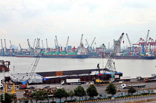 Vessels, passenger ships and tugboats in port under cargo operations and underway. Port of Surabaya, Indonesia, January,2021