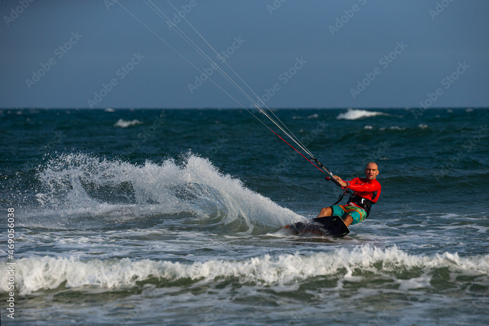 Obraz premium Kitesurfing on the waves of the sea in Mui Ne beach, Phan Thiet, Binh Thuan, Vietnam. Kitesurfing, Kiteboarding action photos. 