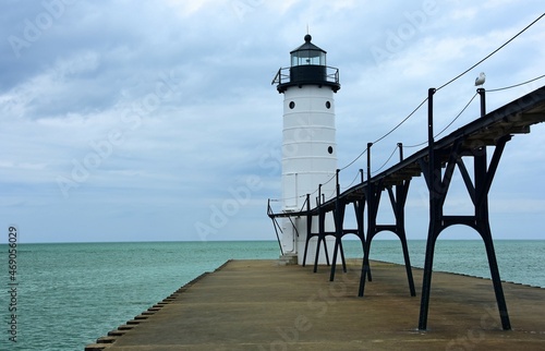 the historic manistee north pierhead lighthouse on fifth avenue beach on eastern lake michigan, michigan, with its elevated  walkway, on a stormy day photo