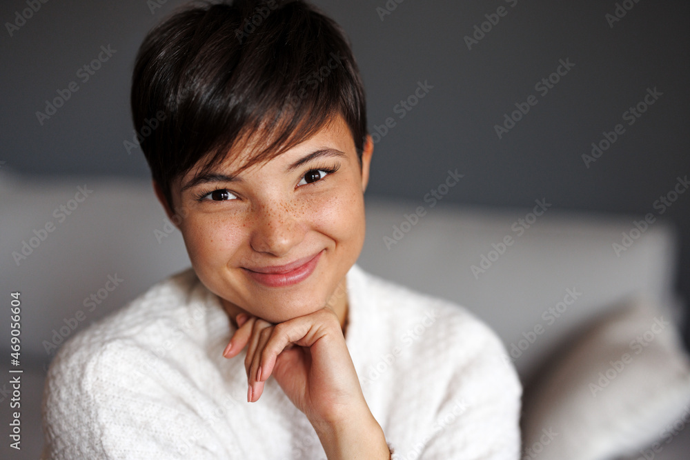 Portrait of a beautiful young smiling woman with freckles on her face and short hair Portrait of a beautiful young smiling woman with freckles on her face and short hair