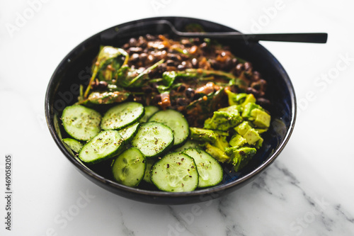 vegan nourish bowl with cucumber avocado and bean mix with spinach