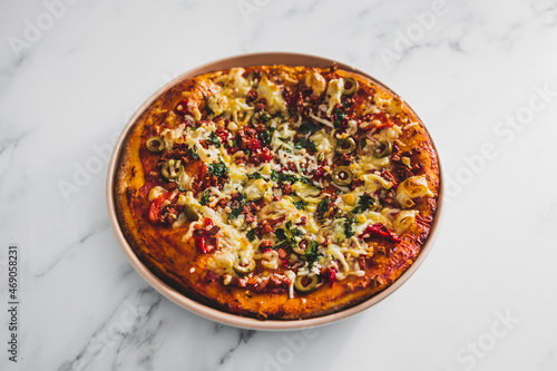 vegan pizza with red pepper olives plant-based bacon bits and dairy-freee cheese, healthy plant-based food