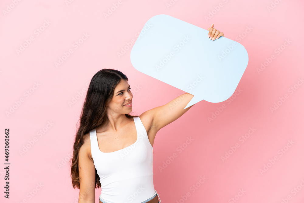 Young caucasian woman isolated on pink background holding an empty speech bubble Young caucasian woman isolated on pink background holding an empty speech bubble