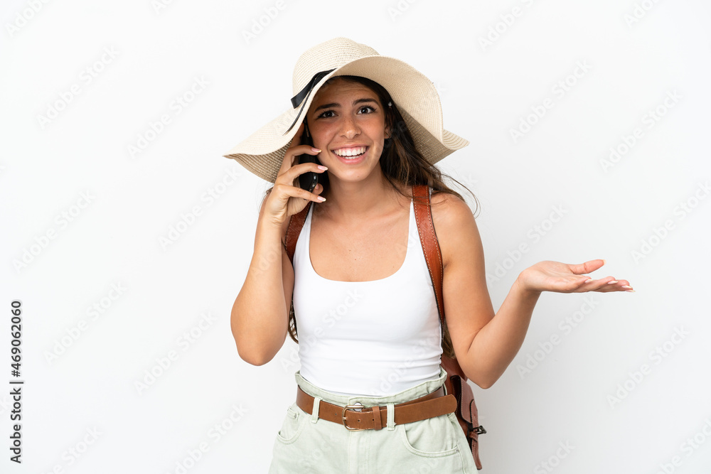 Young caucasian woman wearing a Pamela in summer holidays isolated on white background keeping a conversation with the mobile phone with someone Young caucasian woman wearing a Pamela in summer holidays isolated on white background keeping a conversation with the mobile phone with someone