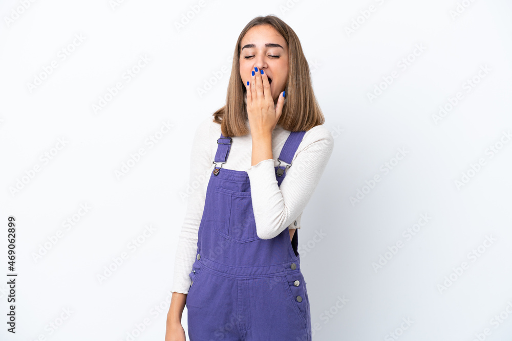 Young caucasian woman isolated on white background yawning and covering wide open mouth with hand Young caucasian woman isolated on white background yawning and covering wide open mouth with hand