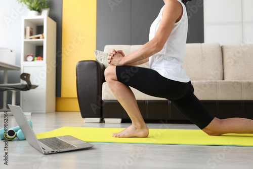 Woman doing stretching at home, online workout