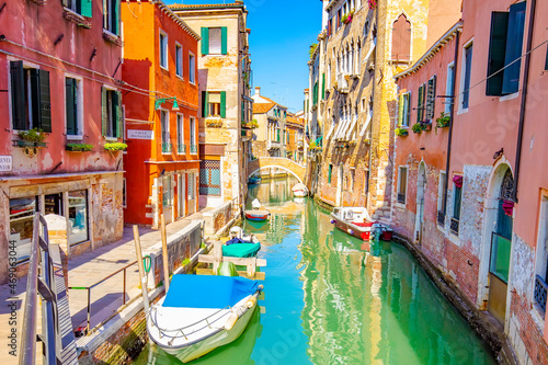 Sunny street with water canal in Venice, Italy