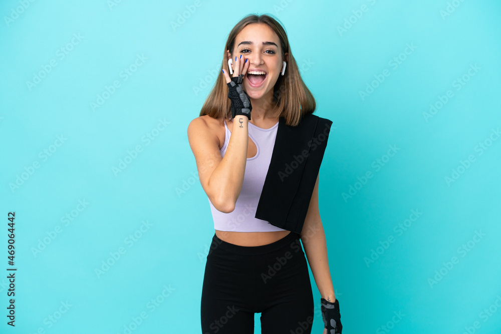 Young sport woman isolated on blue background shouting with mouth wide open Young sport woman isolated on blue background shouting with mouth wide open