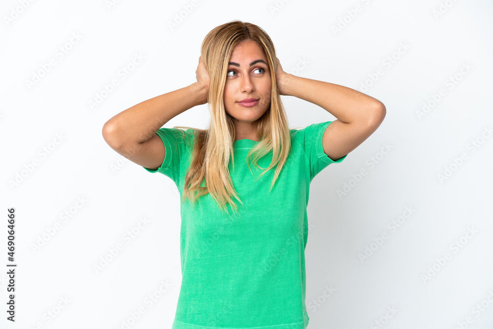 Blonde Uruguayan girl isolated on white background frustrated and covering ears Blonde Uruguayan girl isolated on white background frustrated and covering ears