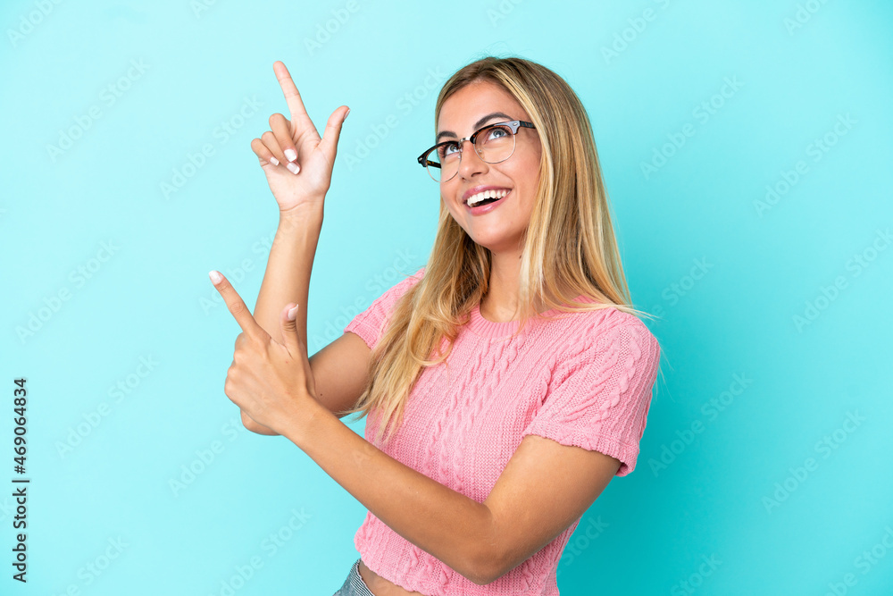 Blonde Uruguayan girl isolated on blue background pointing with the index finger a great idea Blonde Uruguayan girl isolated on blue background pointing with the index finger a great idea