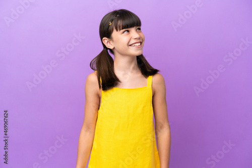 Little caucasian kid isolated on purple background thinking an idea while looking up