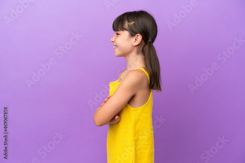 Little caucasian kid isolated on purple background in lateral position