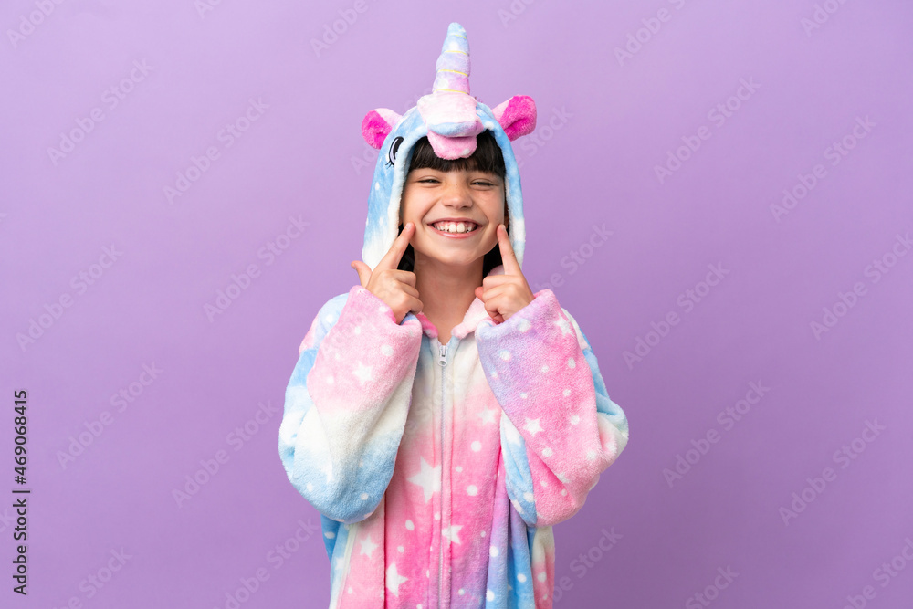 Little kid wearing a unicorn pajama isolated on purple background smiling with a happy and pleasant expression Little kid wearing a unicorn pajama isolated on purple background smiling with a happy and pleasant expression