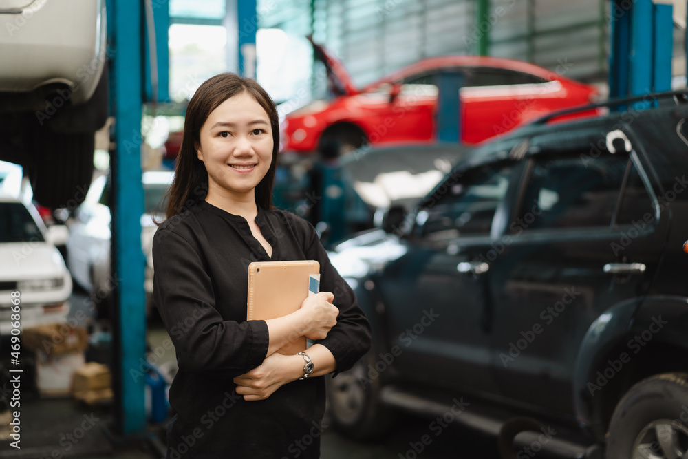 Satisfied Asian young woman in black shirt showing a thumb up in garage. Satisfied Asian young woman in black shirt showing a thumb up in garage.
