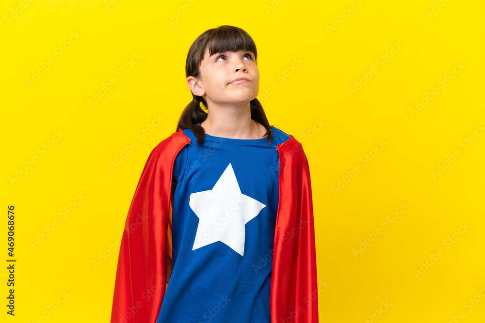 Little super hero kid isolated on purple background and looking up