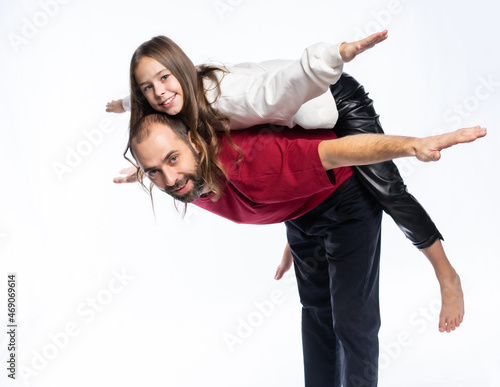 the father put his daughter on his back, the girl spread her arms like wings. isolated background