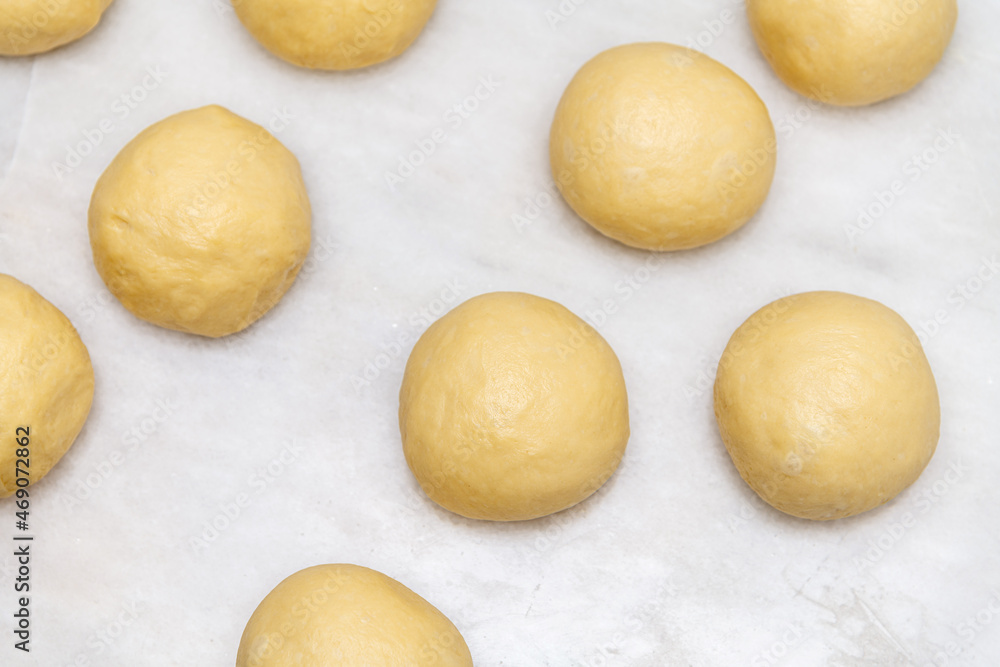 Top view of raw dough balls made for baking pastries on white marble Top view of raw dough balls made for baking pastries on white marble