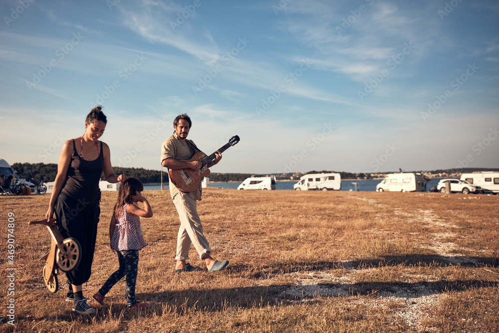 Family on a vacation, singing, playing music on a guitar and enjoying summertime vibes. Family on a vacation, singing, playing music on a guitar and enjoying summertime vibes.