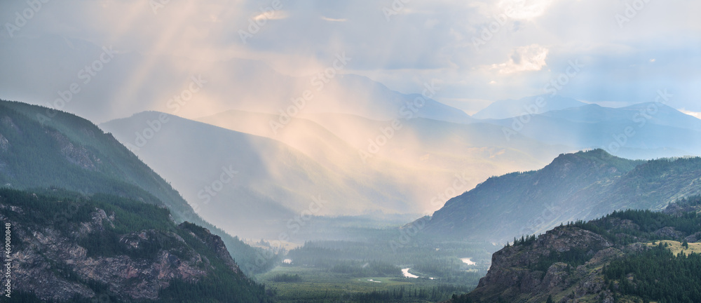Mountain gorge in evening light, illuminated clouds