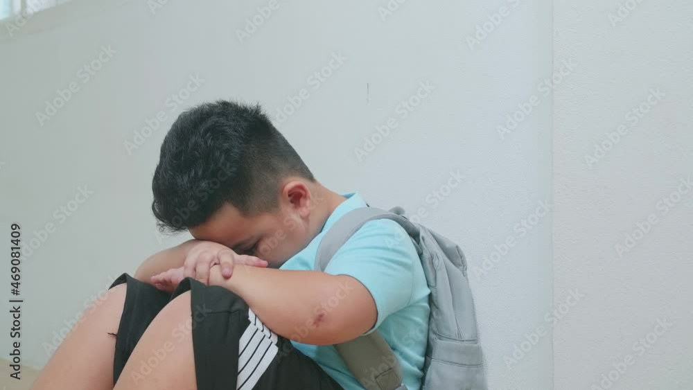 Asian Little Boy Sitting Alone With Sad Feeling At School. Bullying, Discrimination And Racism Concept 
