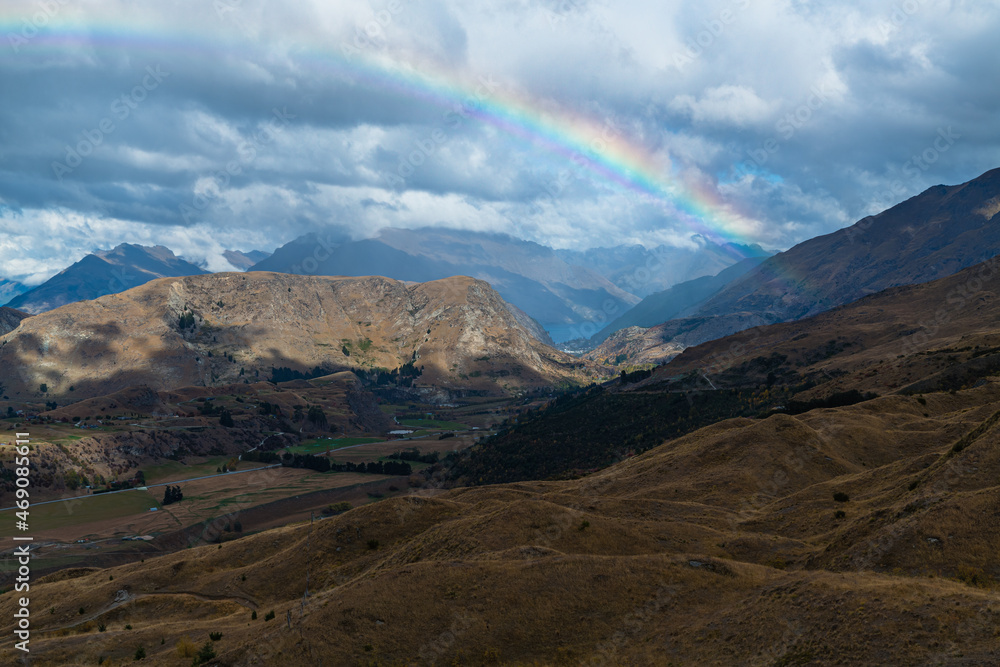 ニュージーランド　クイーンズタウン近郊のスキー場、コロネット・ピークの山上から望む景色と空に架かった虹