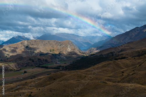 ニュージーランド クイーンズタウン近郊のスキー場、コロネット・ピークの山上から望む景色と空に架かった虹