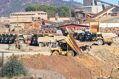 Mining trucks and machinery in Corta Atalaya open mine pit. Deep excavation of pyrite and extraction of minerals of cooper and gold in municipality of Minas de Riotinto, Huelva, Andalusia, Spain photo