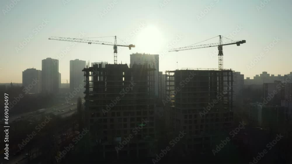 Aerial Flight Over a New Constructions Development Site with High Tower Cranes Building Real Estate. Heavy Machinery and Construction Workers are Employed. Urban Construction Site, Aerial View Aerial Flight Over a New Constructions Development Site with High Tower Cranes Building Real Estate. Heavy Machinery and Construction Workers are Employed. Urban Construction Site, Aerial View