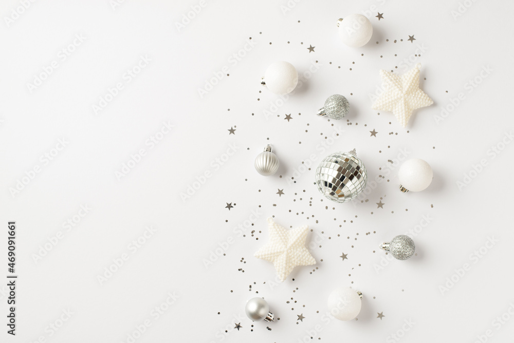 Top view photo of white and silver christmas tree decorations disco balls stars and confetti on isolated white background with copyspace Top view photo of white and silver christmas tree decorations disco balls stars and confetti on isolated white background with copyspace