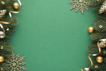 Top view photo of gold and silver christmas tree balls toys cones small bells snowflakes and serpentine on pine branches on isolated green background with empty space