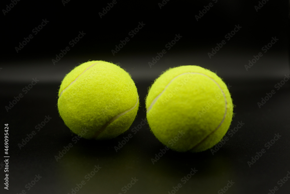 Two tennis balls on a black background