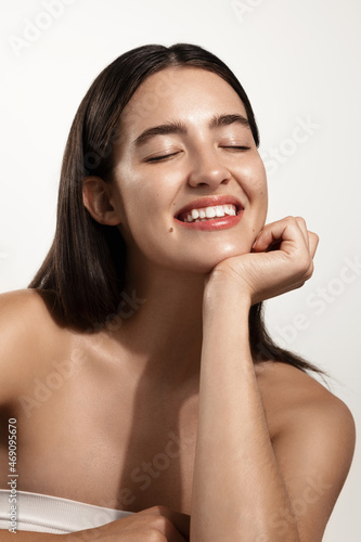 Beauty and spa. Smiling woman with closed eyes with nourished, hydrated skin after skincare product, cosmetic cleansing gel for facial and body, white background