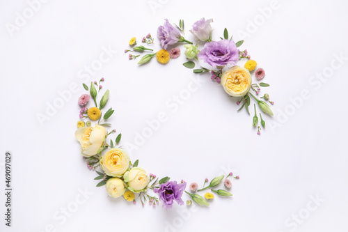 Wreath made of beautiful flowers and green leaves on white background, flat lay. Space for text © New Africa