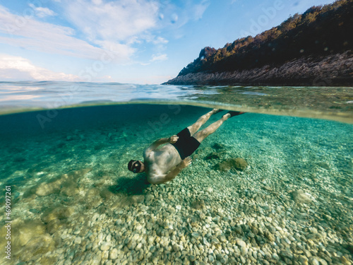 man in diving mask snorkeling in sea water